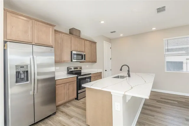 a kitchen with stainless steel appliances a refrigerator sink and microwave