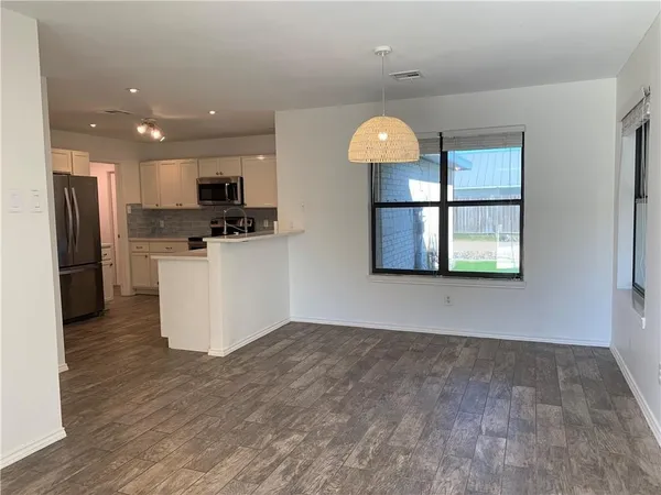 a kitchen with stainless steel appliances granite countertop a refrigerator a stove top oven and a sink with granite countertops