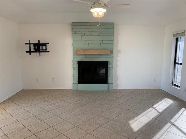 an empty room with windows and fireplace