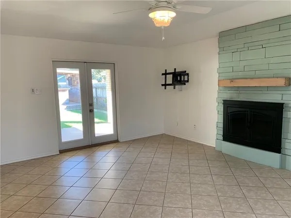 a view of an empty room with window and fire place