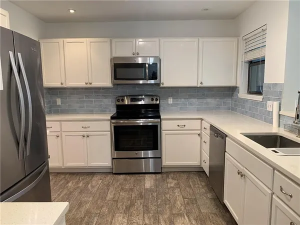 a kitchen with white cabinets and stainless steel appliances