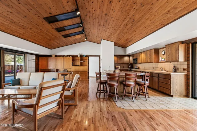 a living room with furniture a wooden floor and next to a window