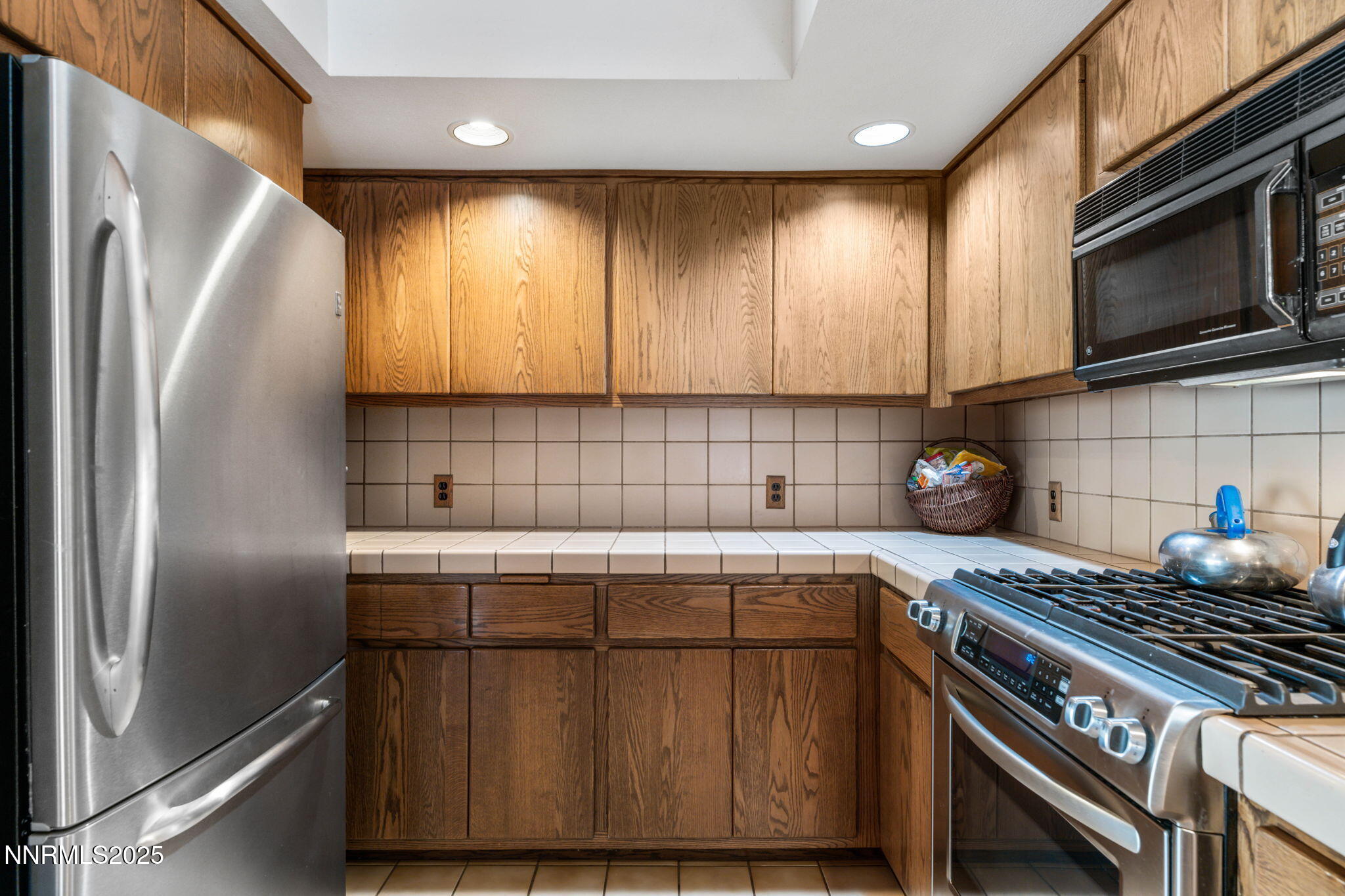 4650 Old Clear Creek Road Carson City, NV 89705 - Photo 26 of 59 a kitchen with stainless steel appliances wooden cabinets a stove and a refrigerator