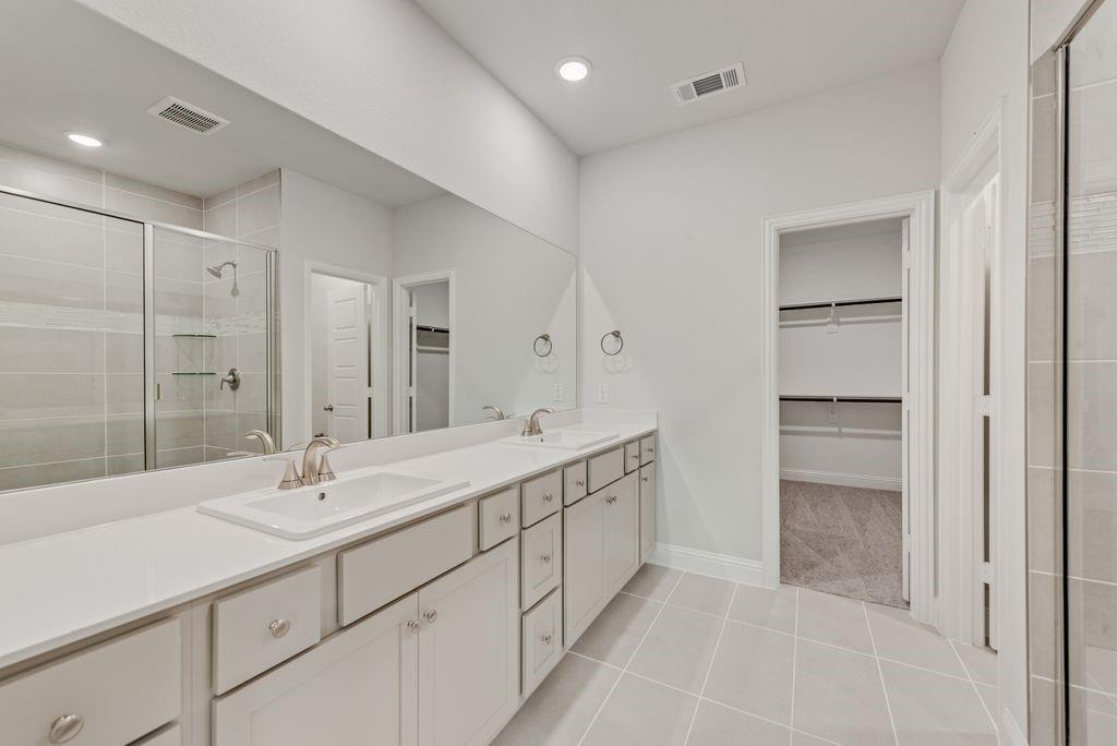 8159 Challenger Lane Frisco, TX 75034 - Photo 13 of 36 a bathroom with a double vanity sink and mirror