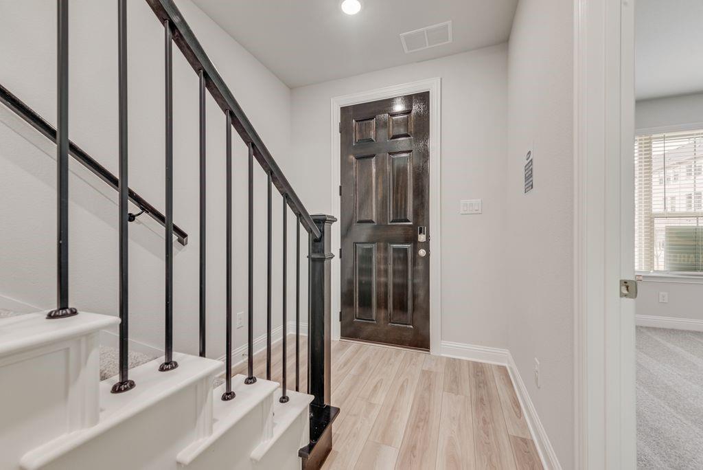 8159 Challenger Lane Frisco, TX 75034 - Photo 17 of 36 a view of a hallway to a livingroom with wooden floor and staircase