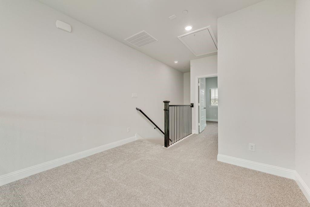 8159 Challenger Lane Frisco, TX 75034 - Photo 20 of 36 an empty room with a ceiling fan and hallway