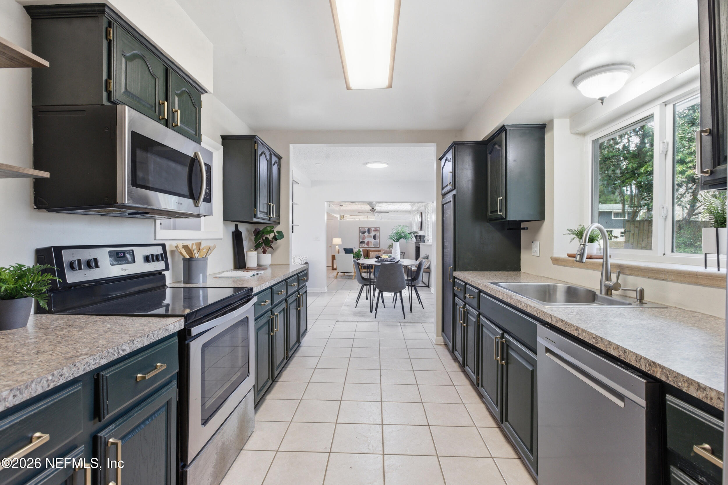 6231 Riviera Manor Drive Jacksonville, FL 32216 - Photo 9 of 33 a large kitchen with stainless steel appliances granite countertop a stove top oven a sink dishwasher a dining table and chairs with wooden floor