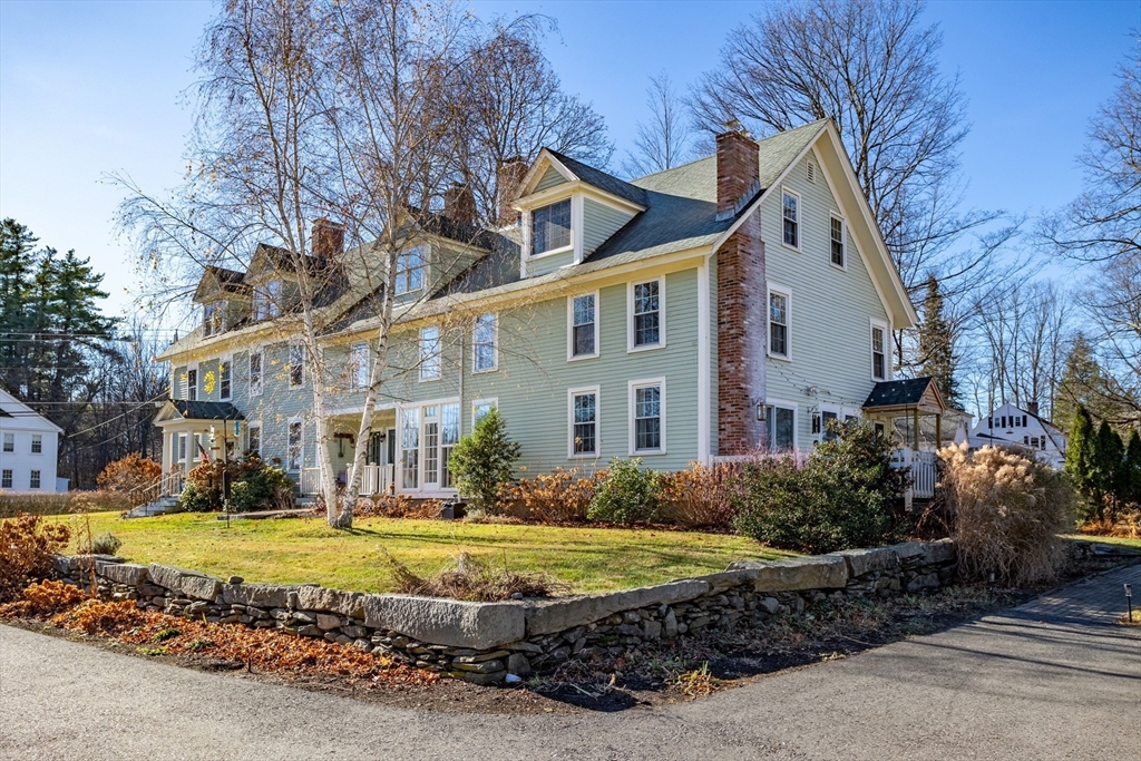 16 Main Street, Unit 3 Pepperell, MA 01463 - Photo 2 of 30 a view of a white house with a big yard plants and large trees