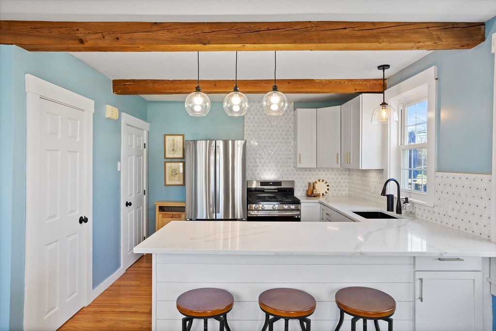 16 Main Street, Unit 3 Pepperell, MA 01463 - Photo 4 of 30 a kitchen with granite countertop a sink a stove and cabinets