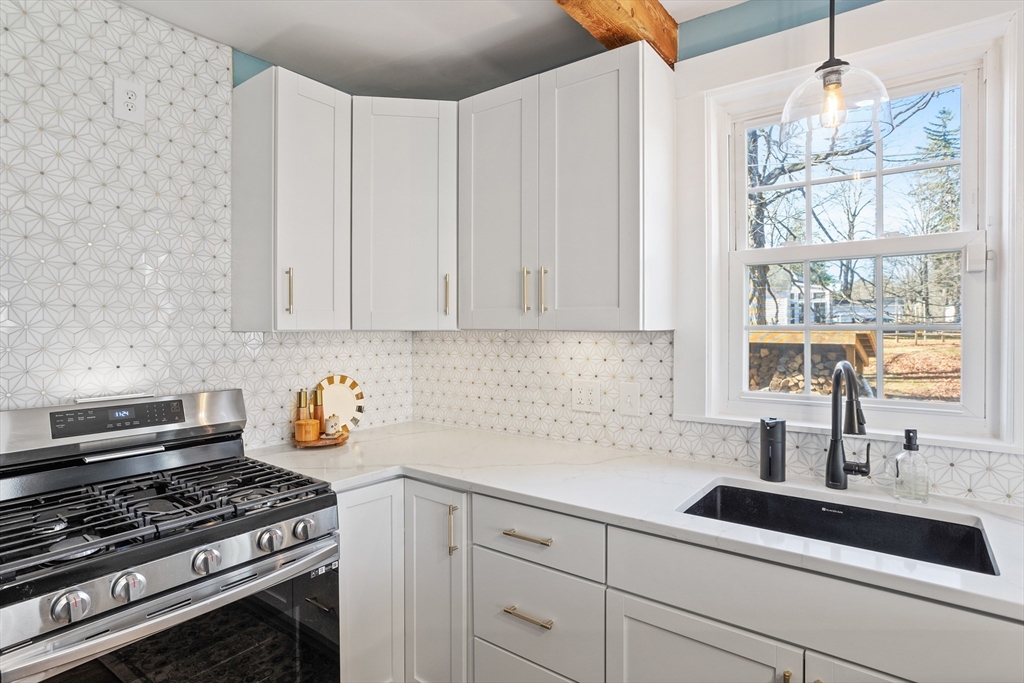 16 Main Street, Unit 3 Pepperell, MA 01463 - Photo 6 of 30 a kitchen with stainless steel appliances a sink a stove and white cabinets