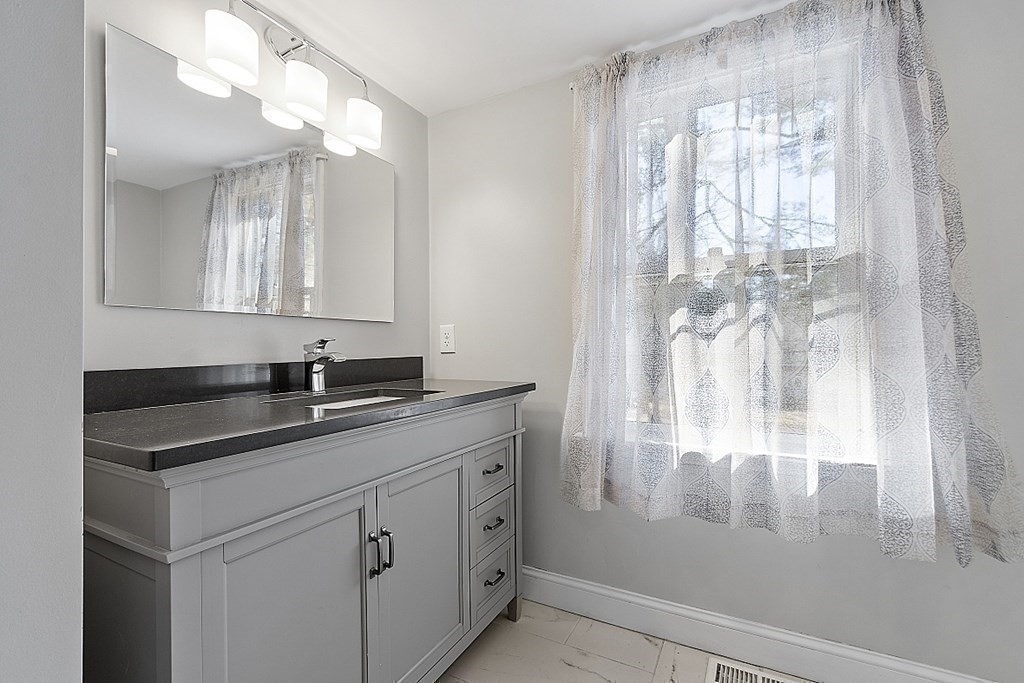 126 South Row Road Lunenburg, MA 01462 - Photo 18 of 28 a bathroom with a sink a mirror a vanity and a shower