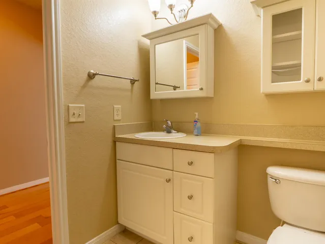 a bathroom with a sink mirror vanity and toilet