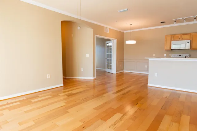a view of a room with wooden floor and a flat screen tv