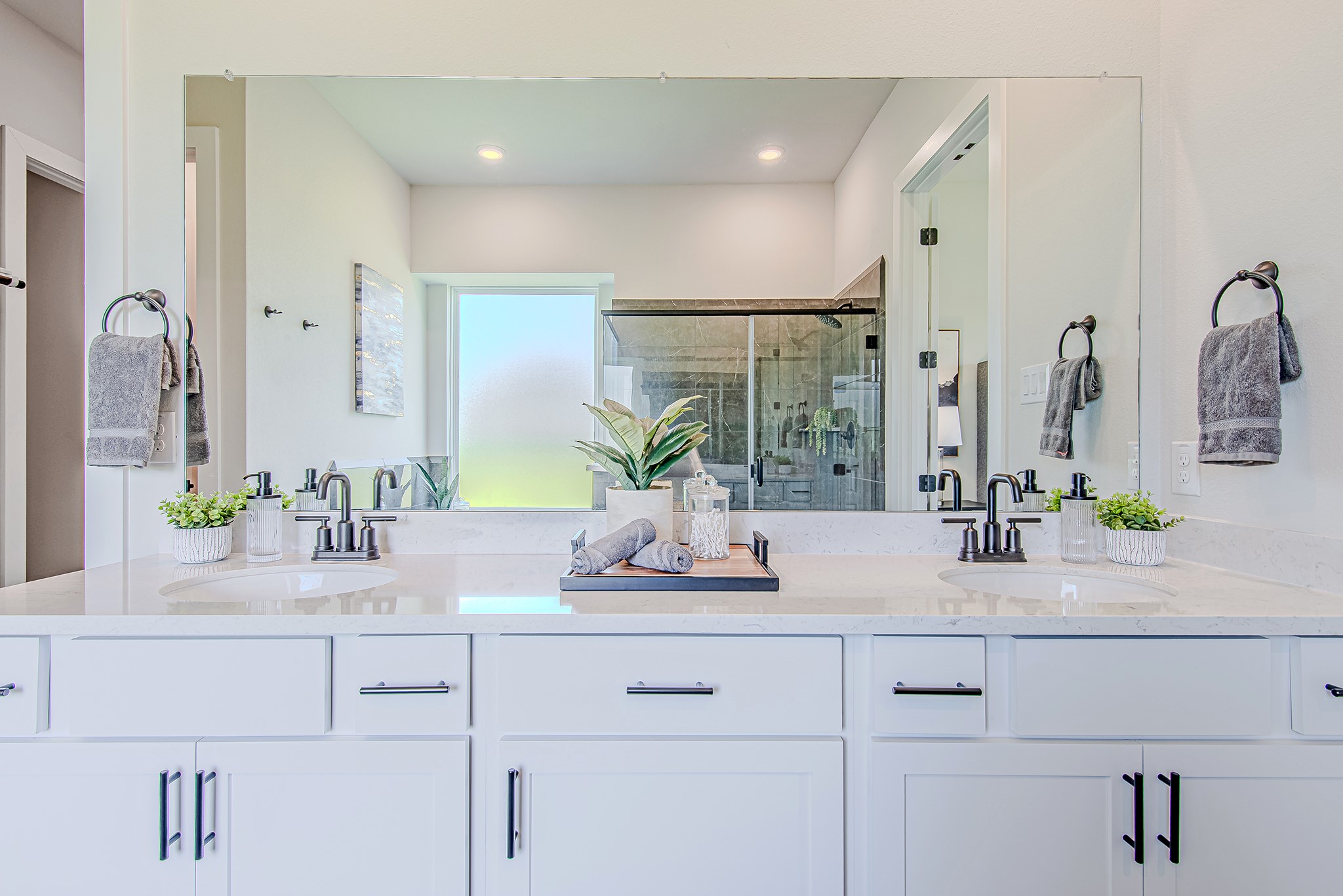 141 Peninsula Point Drive Montgomery, TX 77356 - Photo 22 of 47 Dual vanities with quartz counters and matte black fixtures offer ample space and style in the spa-worthy primary bathroom.