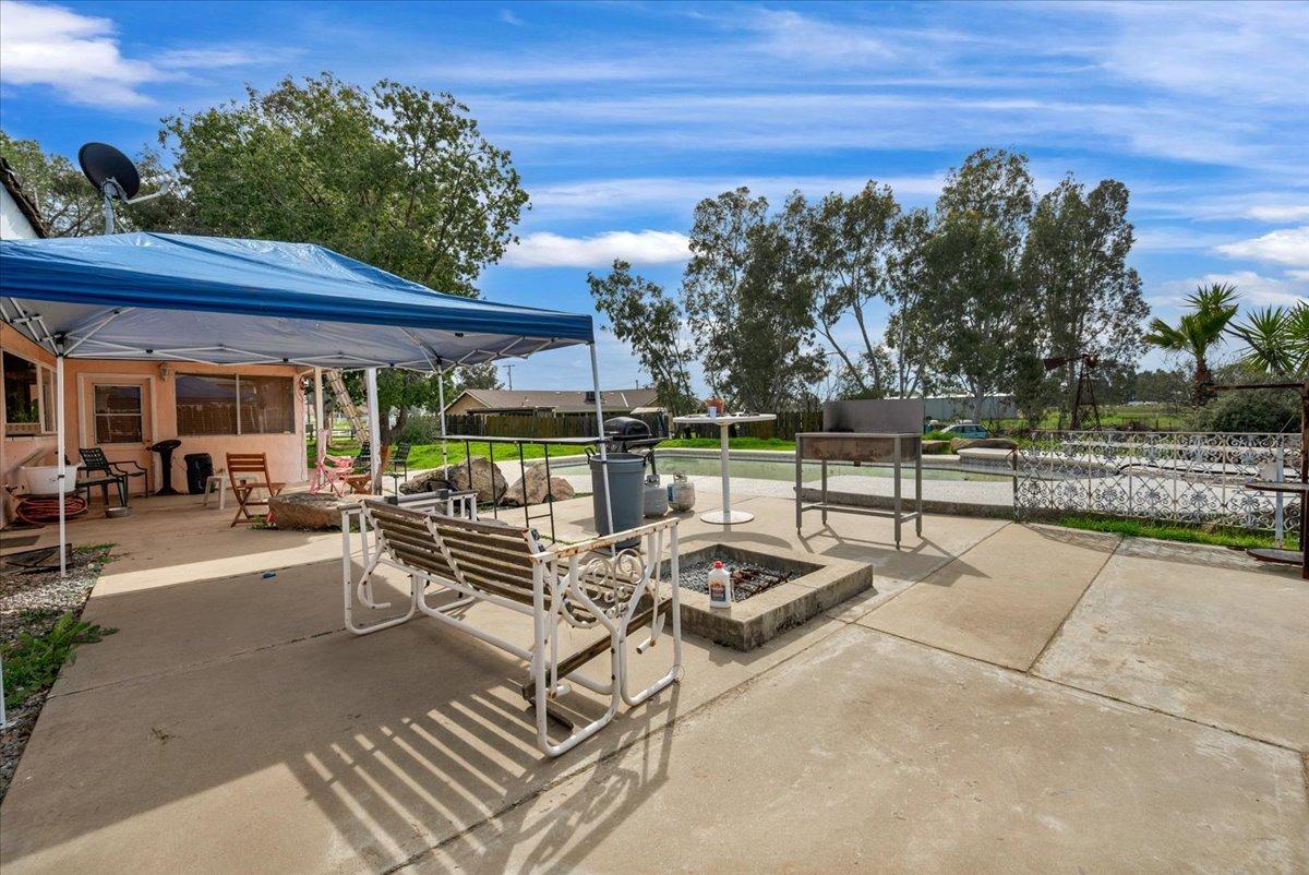 16860 Mark Road Madera, CA 93636 - Photo 40 of 76 a view of a patio with table and chairs potted plants and a large tree