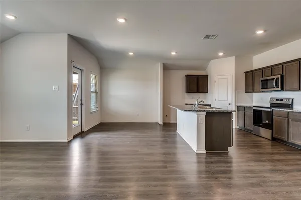 a view of kitchen with microwave and refrigerator