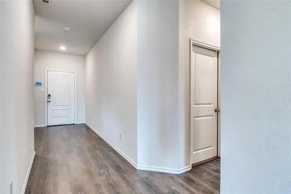 a view of a hallway with wooden floor