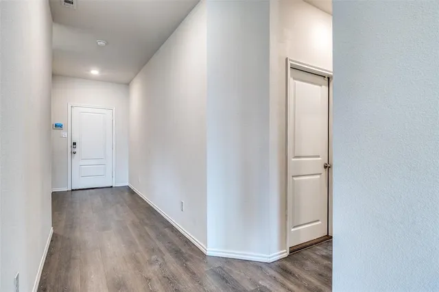 a view of a hallway with wooden floor