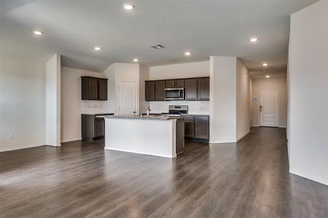 a view of kitchen with microwave a stove a sink and a refrigerator