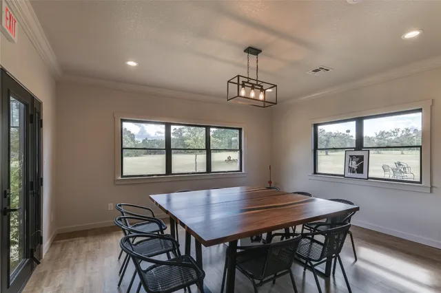 a view of a dining room with furniture a chandelier and wooden floor