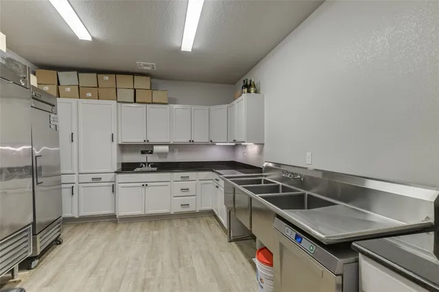 a kitchen that has a sink a stove and cabinets