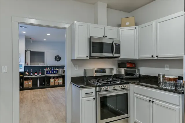 a kitchen with stainless steel appliances granite countertop a stove a microwave and a refrigerator