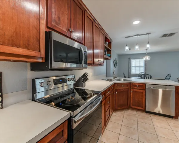 a kitchen with stainless steel appliances a stove sink microwave and cabinets