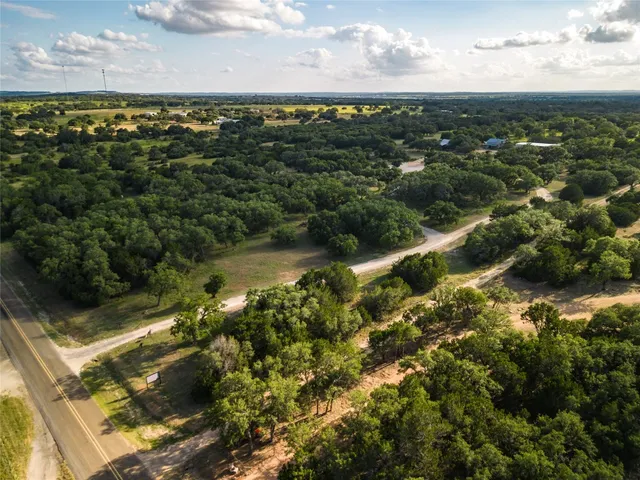 an aerial view of residential houses with outdoor space and trees