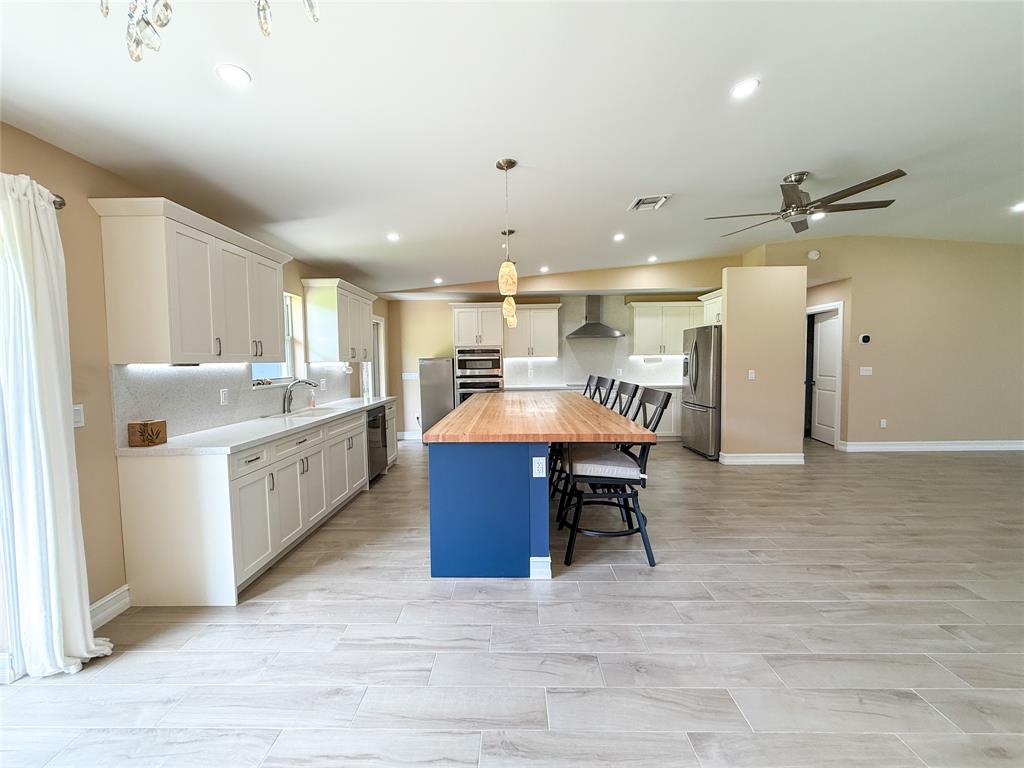 17420 Southwest 54th Street Southwest Ranches, FL 33331 - Photo 12 of 34 a large white kitchen with a large island in the center