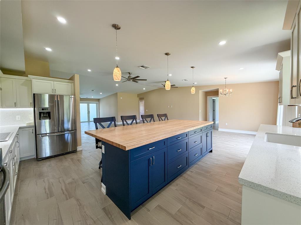 17420 Southwest 54th Street Southwest Ranches, FL 33331 - Photo 14 of 34 a large kitchen with stainless steel appliances kitchen island granite countertop a large counter top and a refrigerator