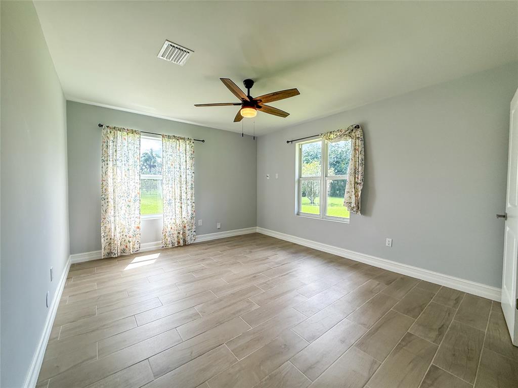 17420 Southwest 54th Street Southwest Ranches, FL 33331 - Photo 31 of 34 an empty room with wooden floor and windows