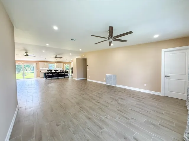 a view of a big room with wooden floor and a ceiling fan