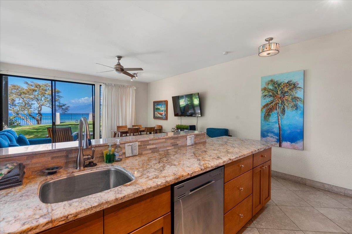 5271 Lower Honoapiilani Road, Unit B44 Lahaina, HI 96761 - Photo 5 of 25 a kitchen with granite countertop a sink and a refrigerator
