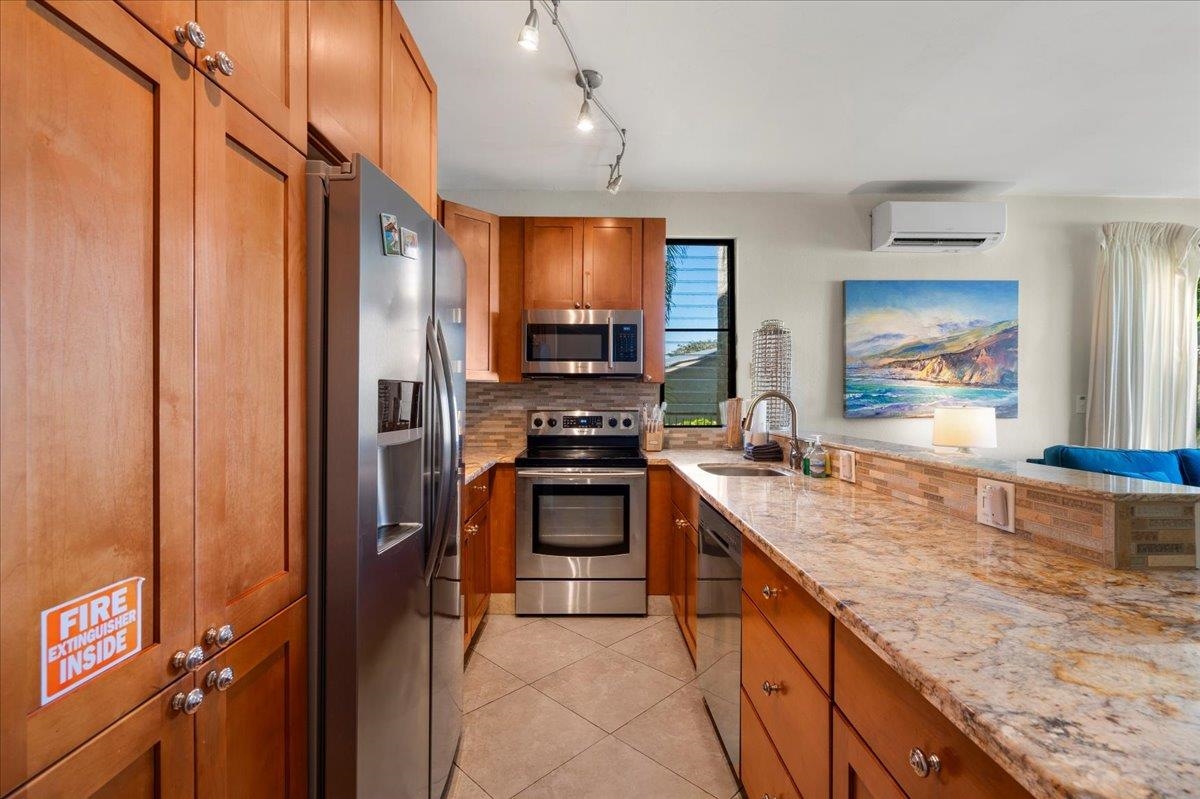 5271 Lower Honoapiilani Road, Unit B44 Lahaina, HI 96761 - Photo 7 of 25 a kitchen with stainless steel appliances granite countertop a stove a sink and a refrigerator