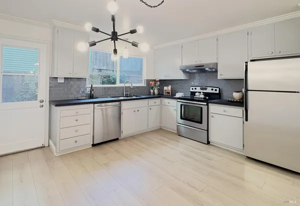 a kitchen with stainless steel appliances a sink stove and refrigerator