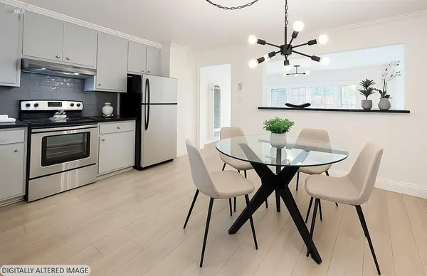 a kitchen with stainless steel appliances a stove a microwave and white cabinets