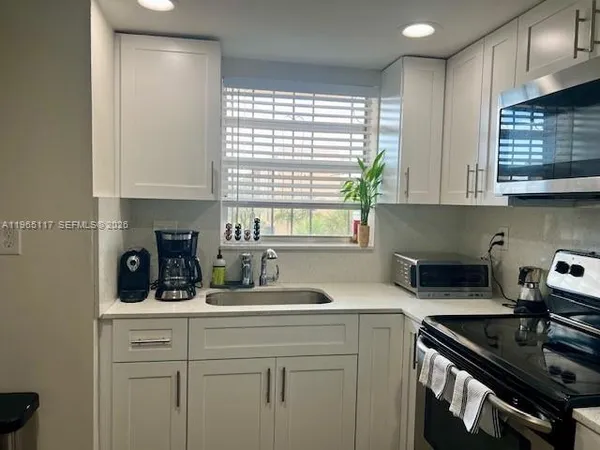 a kitchen with a sink stove and cabinets