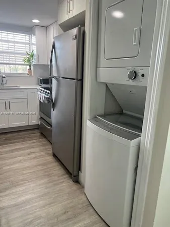a kitchen with a refrigerator sink and cabinets