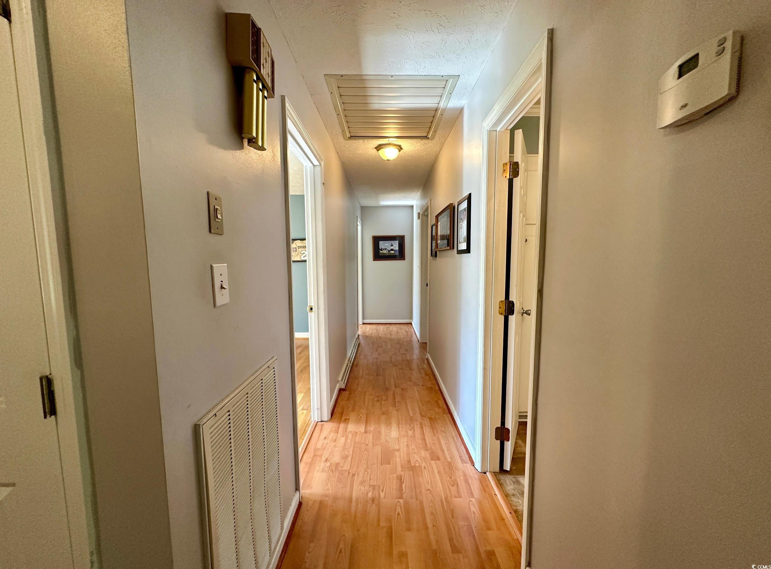 601 Jefferson Street Bennettsville, SC 29512 - Photo 11 of 20 Hall with light wood finished floors, cooling unit, and a textured ceiling