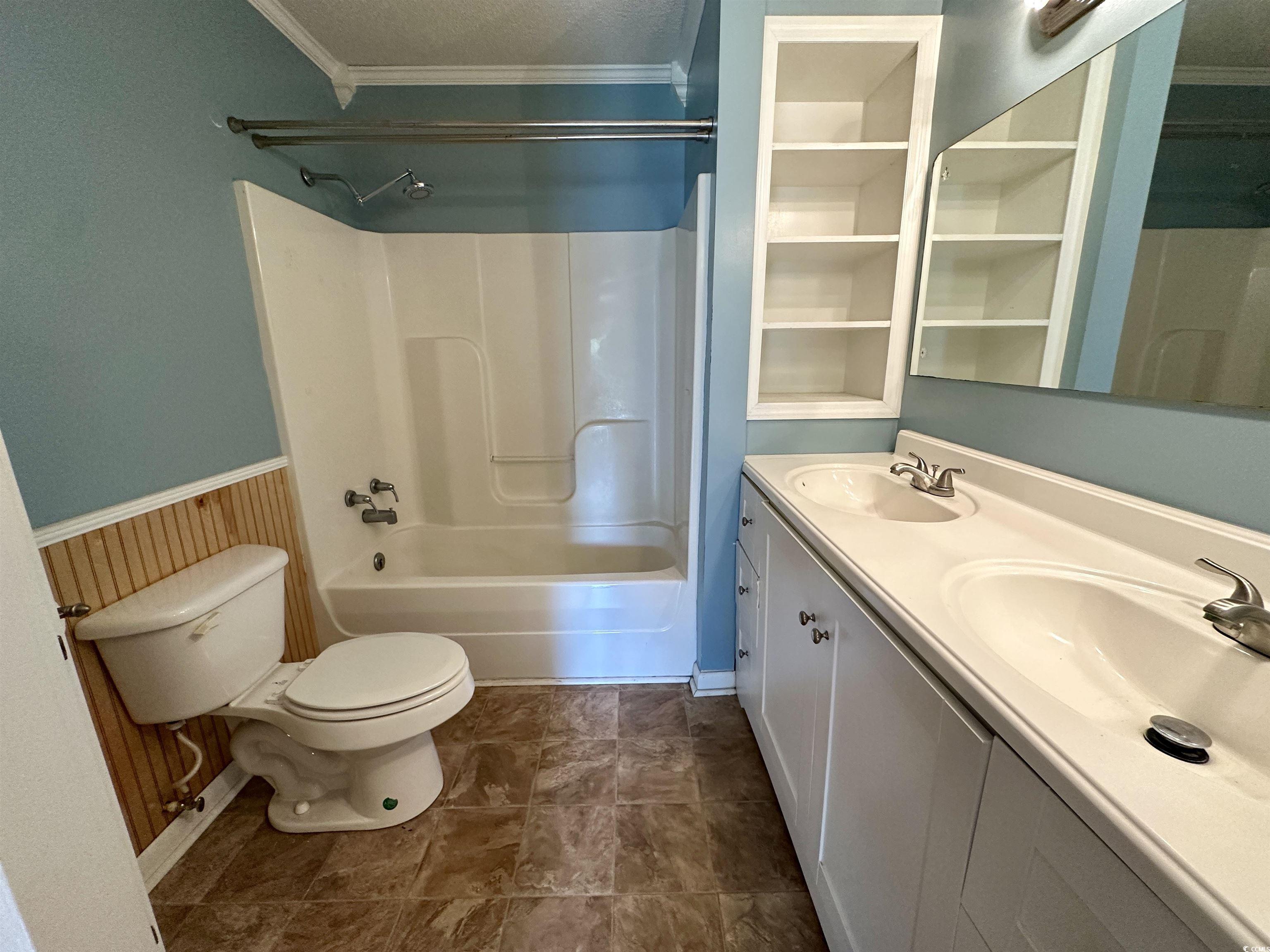 601 Jefferson Street Bennettsville, SC 29512 - Photo 14 of 20 Bathroom with tub / shower combination, ornamental molding, a wainscoted wall, double vanity, and wooden walls