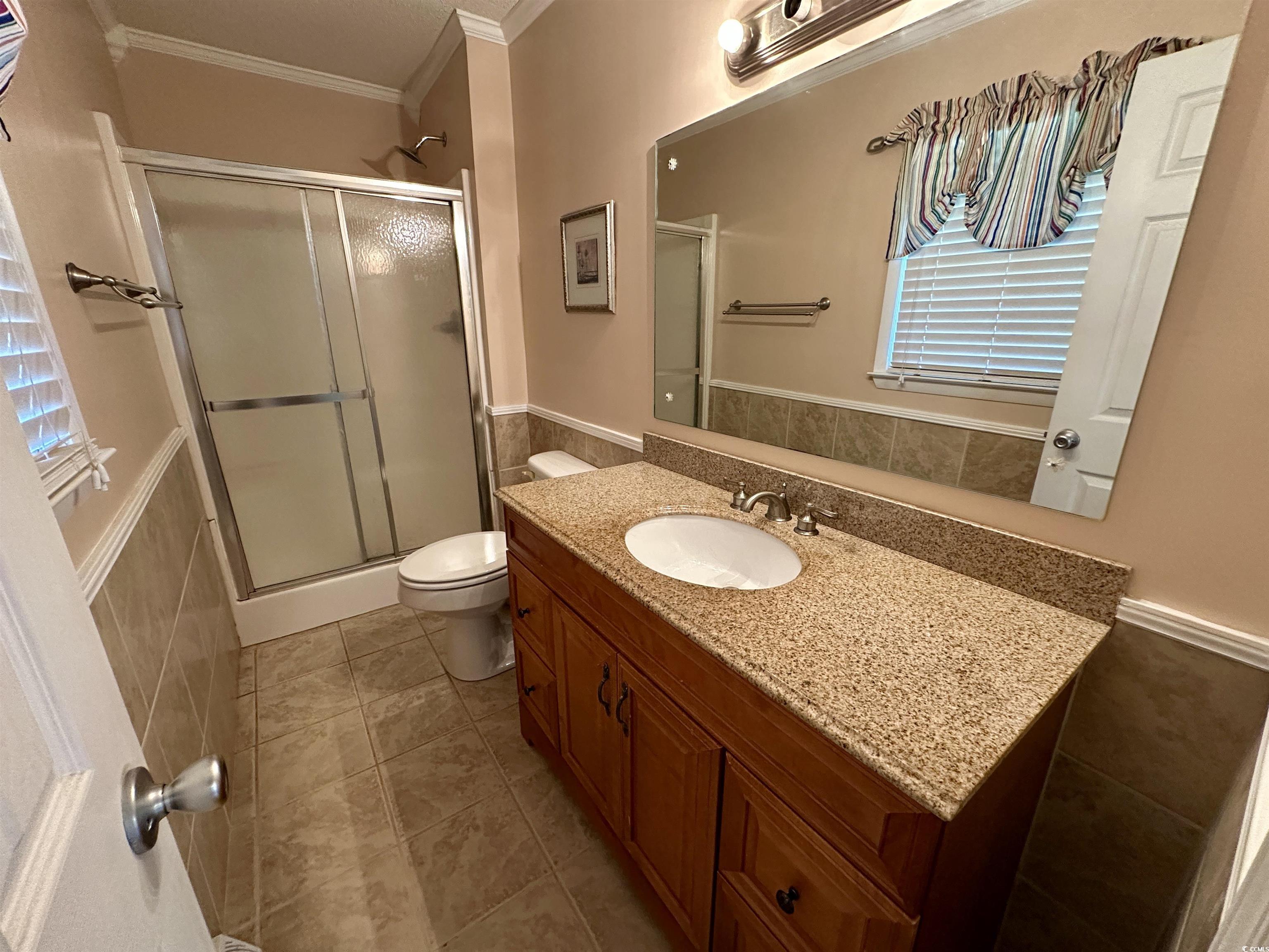 601 Jefferson Street Bennettsville, SC 29512 - Photo 19 of 20 Full bathroom with crown molding, vanity, a stall shower, light tile patterned floors and wall