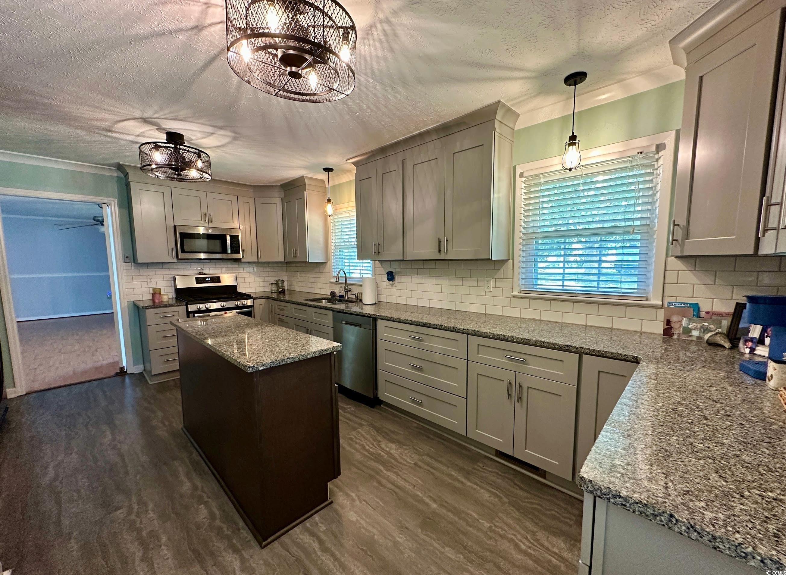 601 Jefferson Street Bennettsville, SC 29512 - Photo 7 of 20 Kitchen with gray cabinetry, a textured ceiling, hanging light fixtures, light stone countertops, and stainless steel appliances