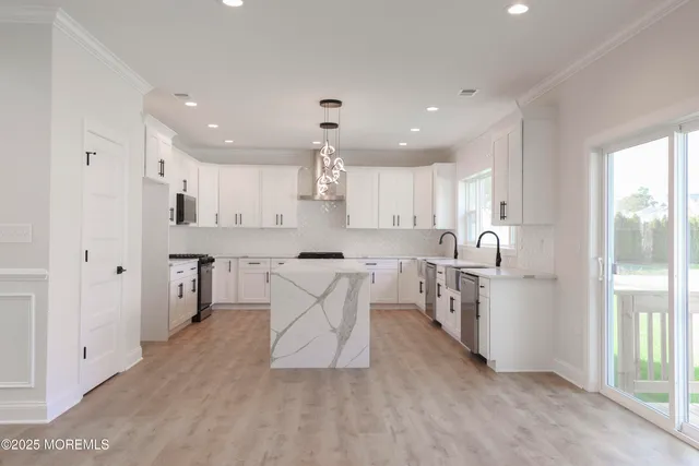 a large kitchen with kitchen island a stove a sink a oven and a large window