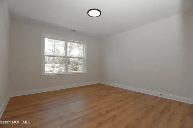 a view of a room with wooden floor and windows