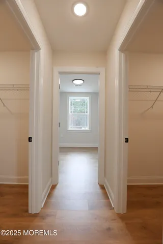 a view of a hallway with wooden floor and windows