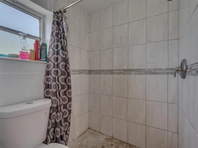 a bathroom with a toilet and a shower curtain