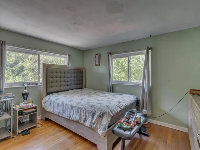a bedroom with a bed and large windows