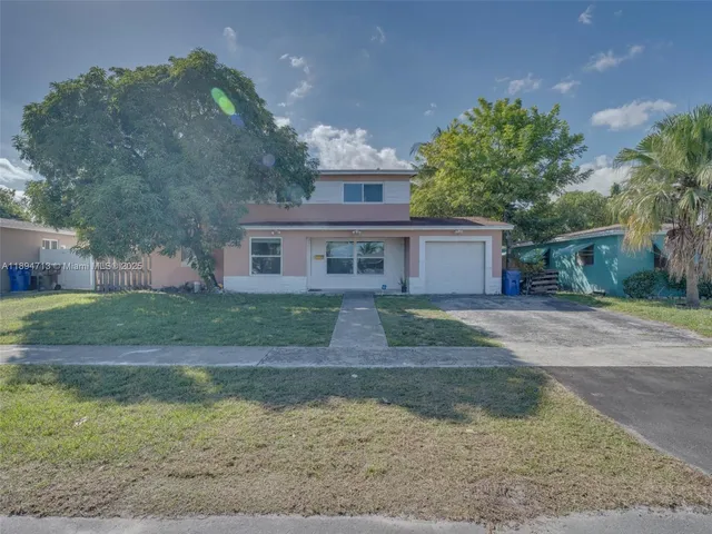 a front view of a house with a yard and a garage