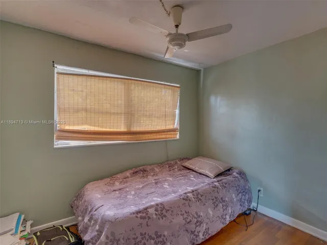 a view of a hallway with wooden floor and a bedroom