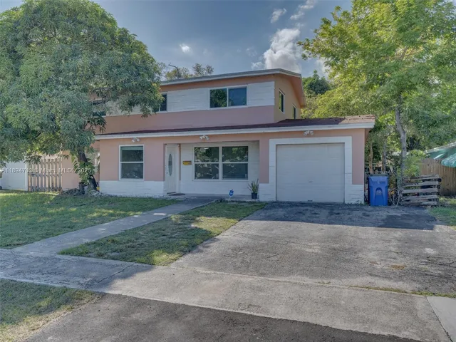 a front view of a house with a yard and a garage